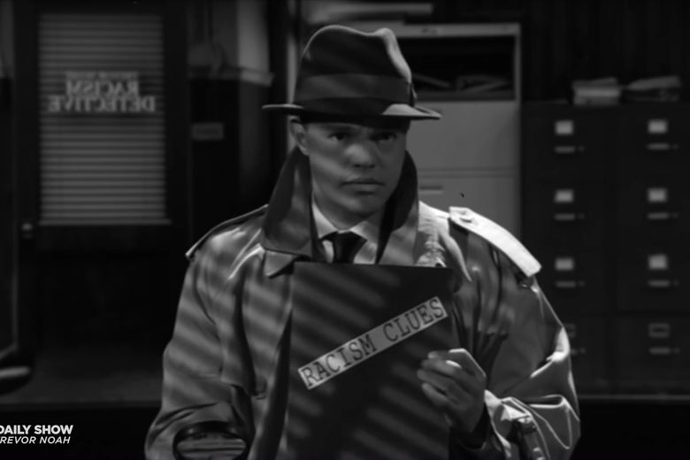 Trevor Noah dressed as a 1940s detective, holding a folder labeled "racism clues."